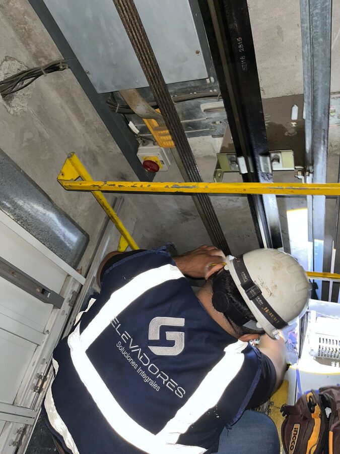 Técnicos G4 realizando mantenimiento en foso de ascensor